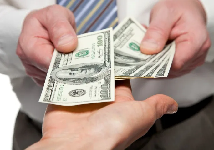 Três mãos segurando cédulas de dólar demonstrando transação de contas a pagar com sucesso