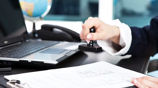 Assinatura de contrato de negócio com laptop e globo para gestão de orçamentos