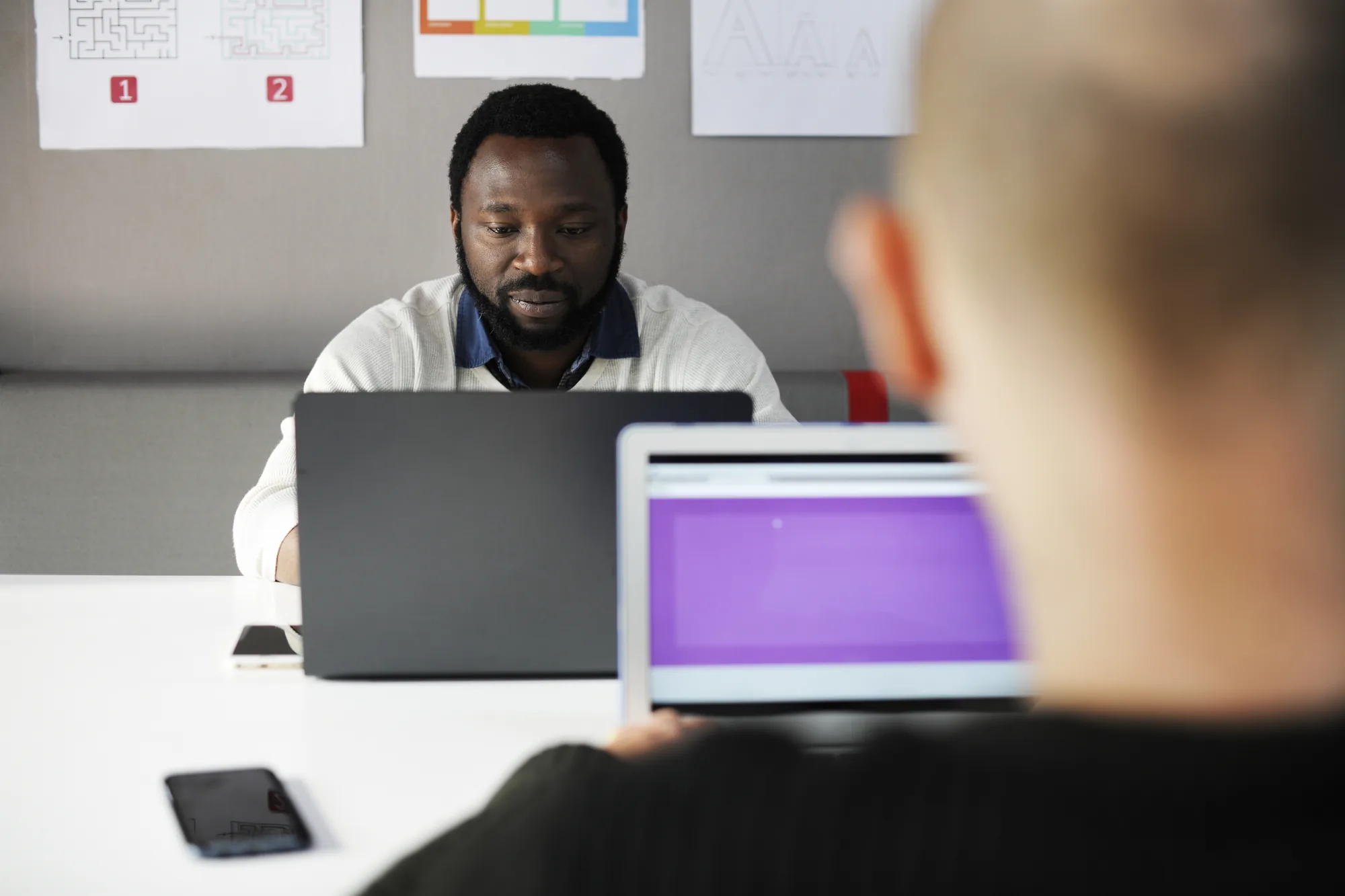 Profissional em reunião com laptop e tablet representando ambiente mei ltda de trabalho