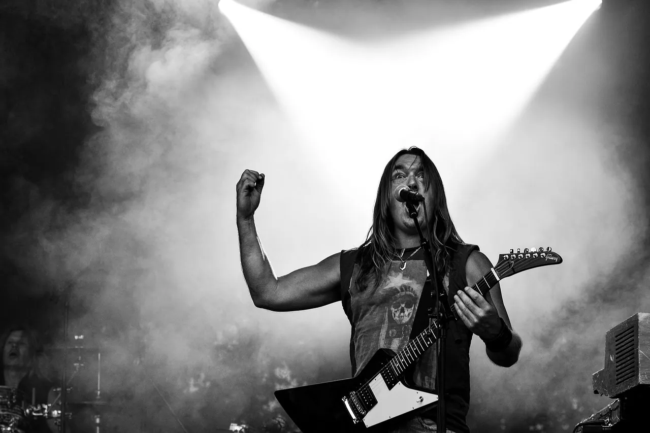 Cantor em palco com iluminação tocando guitarra sobre diploma in international financial reporting