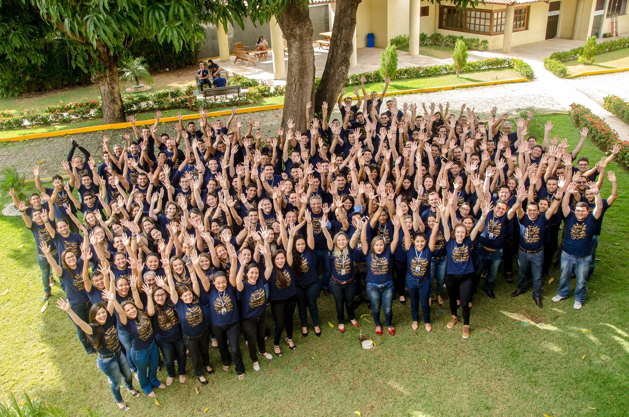 Equipe completa Casa Magalhaes reunida colaboradores em pátio com paisagem verde