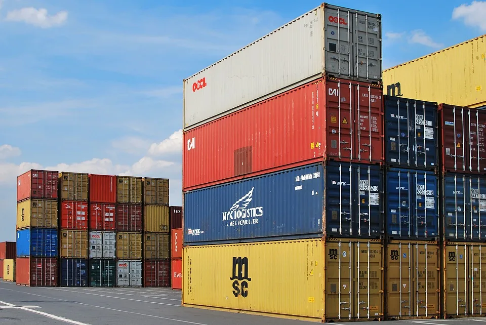 Pilha de contêineres colorida em terminal portuário demonstrando operações de exportação