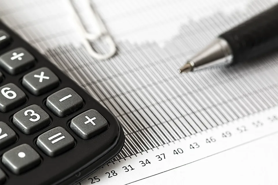 Calculadora com caneta sobre documentos financeiros para cálculo de impostos de exportação