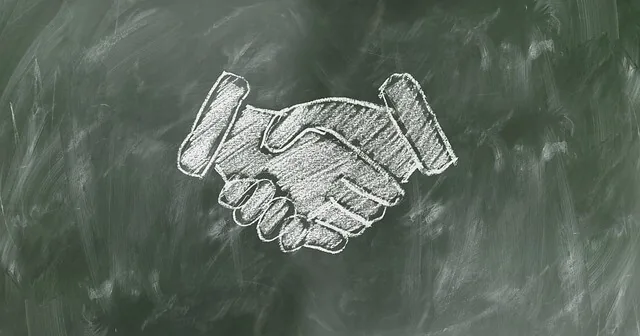 Desenho giz aperto mão quadro-negro representando acordo joint venture significado