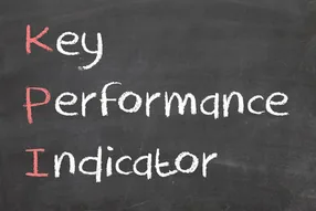 Lousa preta com iniciais KPIs (key performance indicators) escritas em giz branco