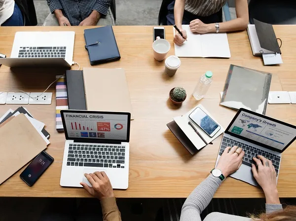 Equipe em reunião analisando importância da matemática financeira em gráfico de crise