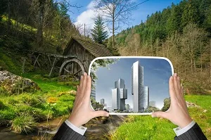 Mãos segurando espelho refletindo cidade representando perspectiva clara do valor presente líquido