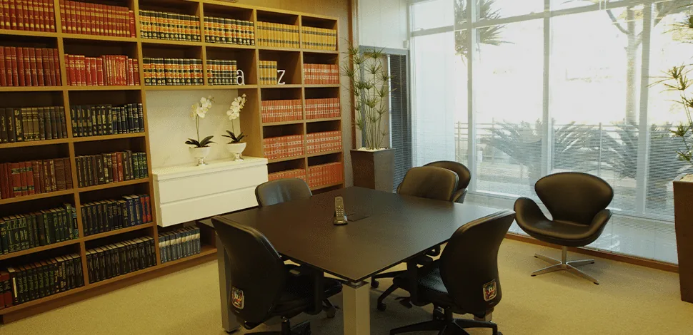 Interior do escritório Reis Advogados com biblioteca jurídica e prática orçamentária